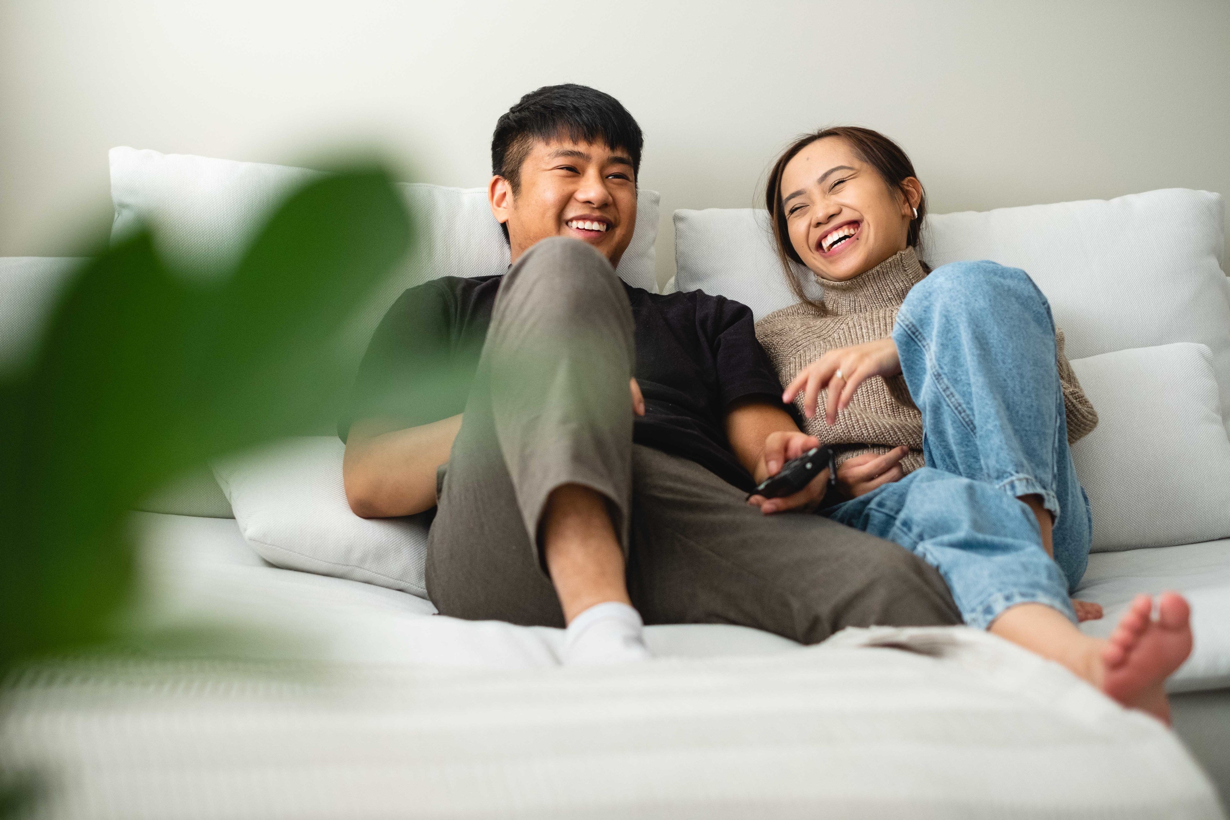 files/a-couple-laughing-and-relaxing-together-on-their-couch.jpg